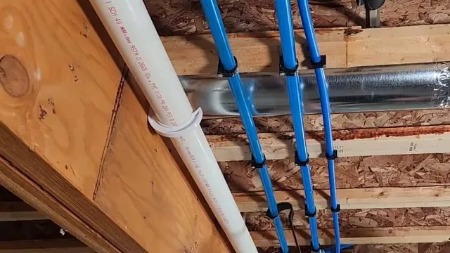 Blue PEX tubing clipped to wooden joists beside a white pipe and a silver duct.